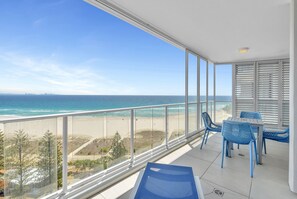 A balcony with a view of the beach and ocean.