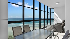 A modern room with a large glass wall offering a view of the ocean. - Reflection Tower Two (Coolangatta)