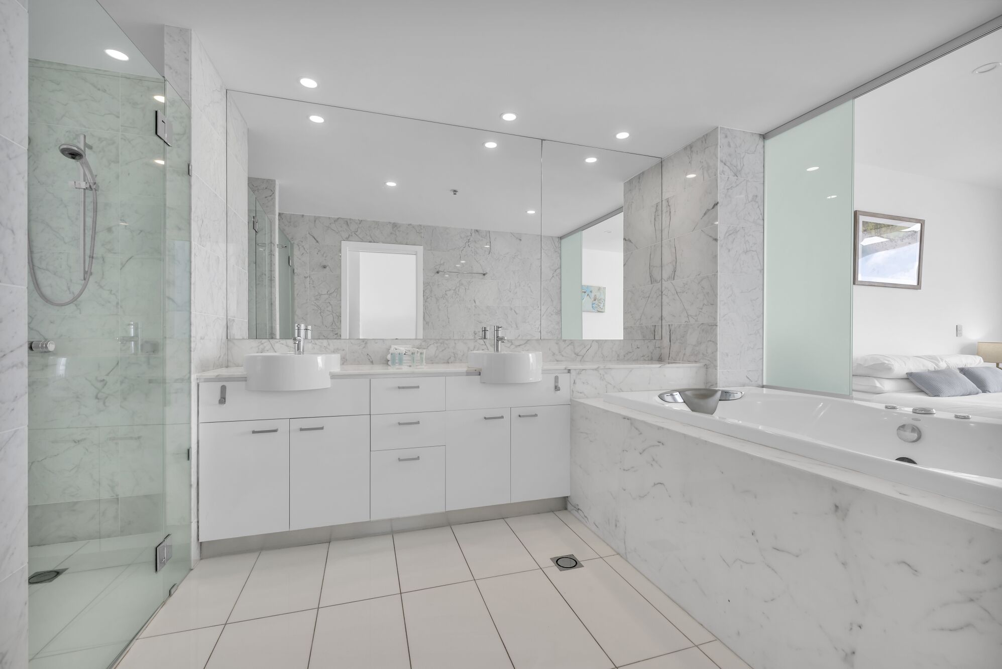 Un baño moderno con dos lavamanos, un espejo grande y una zona de ducha.