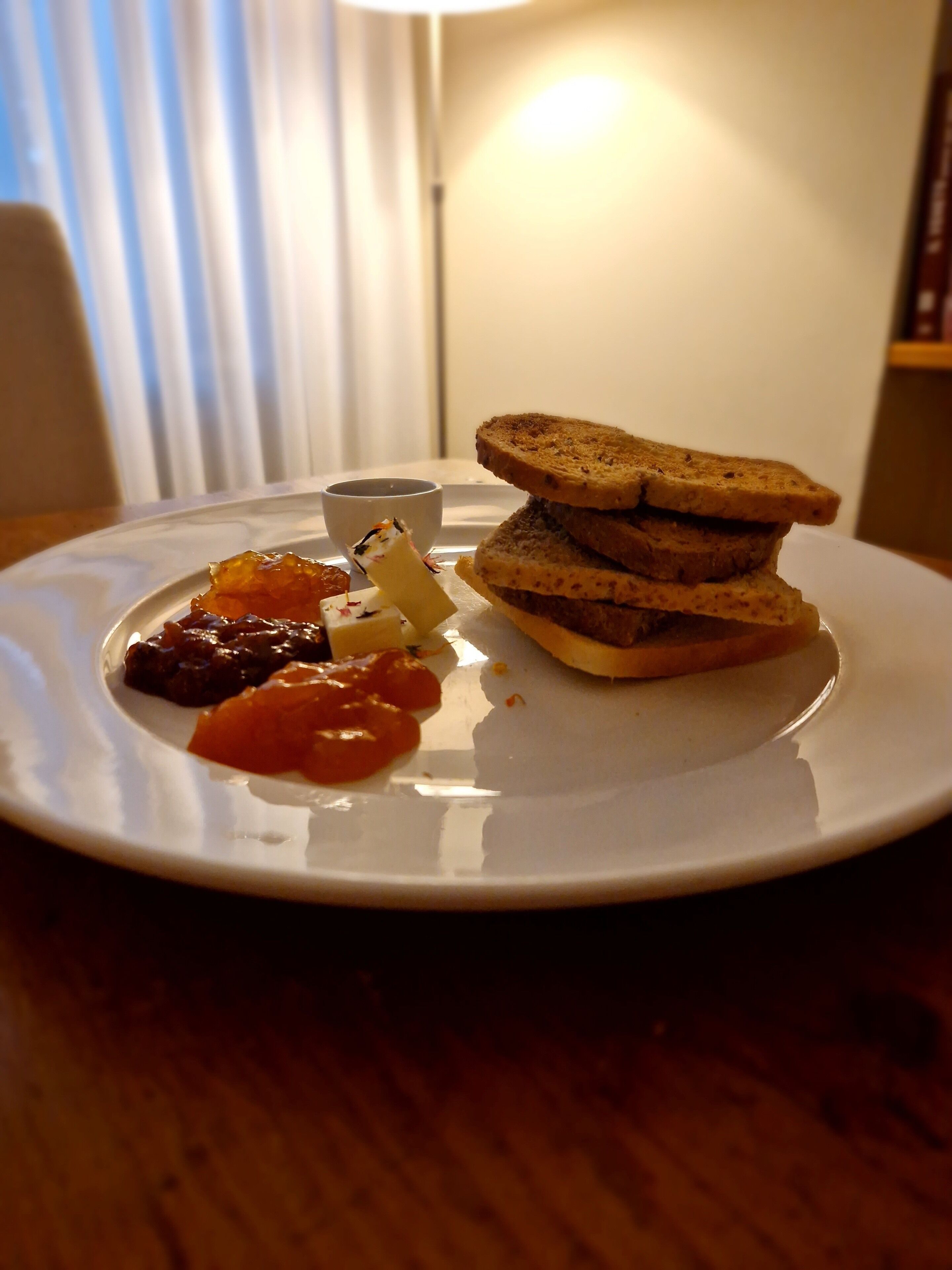 Un plat amb un entrepà, una tassa petita i alguns condiments.