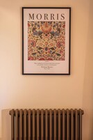 A framed artwork titled 'MORRIS' with a quote by William Morris, featuring a floral and bird pattern.