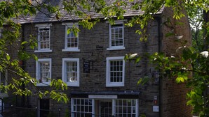 A stone building with multiple windows and a sign that reads "Brunswick House." - Brunswick House (Barnard Castle)