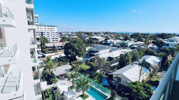 Uma área residencial com casas modernas, piscina e vista para montanhas ao longe.