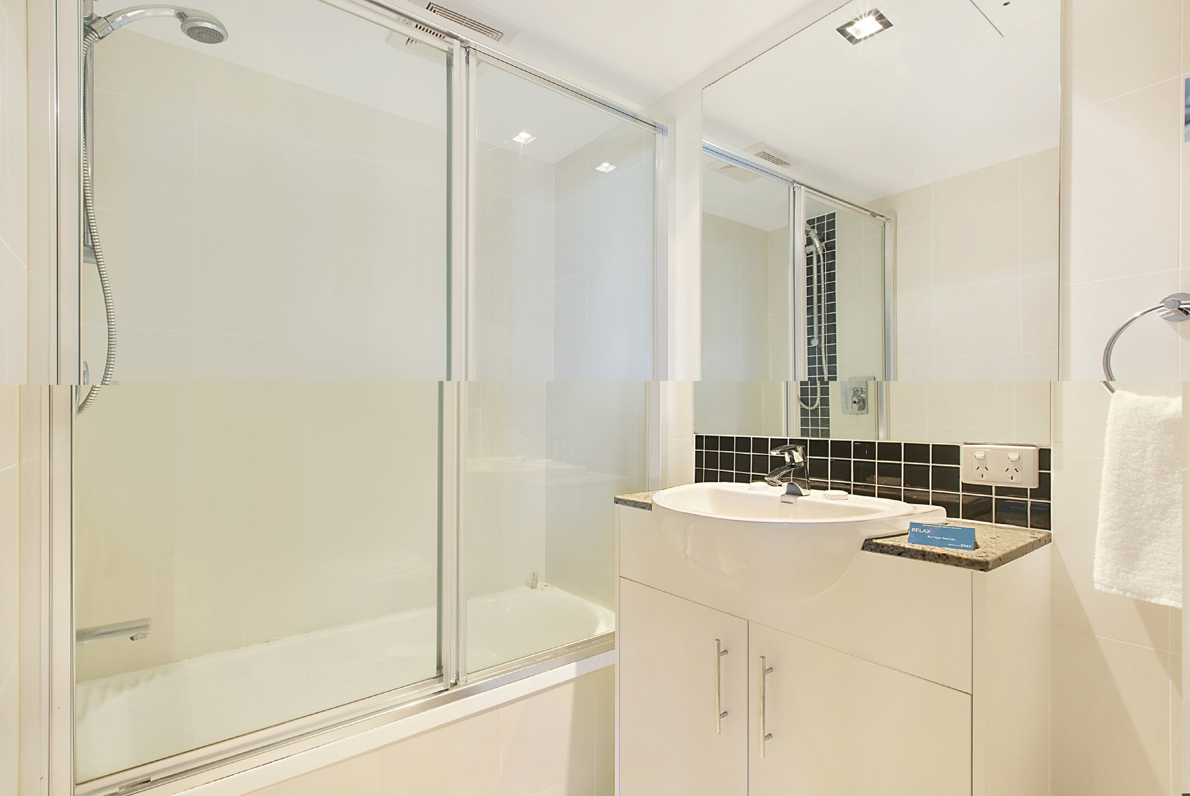 A modern bathroom with a glass shower enclosure, a white sink, and a mirror above it.
