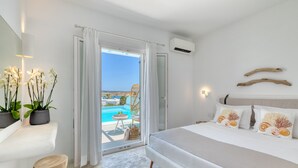 Un dormitorio con una cama grande, vistas a una piscina y un balcón.