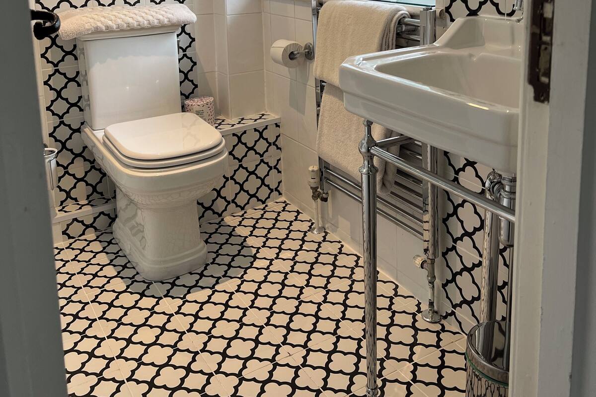 A bathroom with a toilet, sink, and window.
