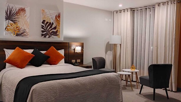 A hotel room with a bed, a desk, a chair, and a lamp. - La Gruta (Arequipa)