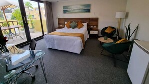 A hotel room with a bed, a desk, a chair, a lamp, and a view of the outdoors. - La Gruta (Arequipa)