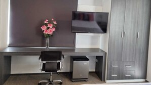 A modern office space with a desk, chair, TV, and storage cabinets. - La Gruta (Arequipa)