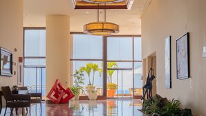 A spacious lobby with large windows, a modern chandelier, and a red geometric sculpture. - Venezuela Marriott Hotel Playa Grande (Urimare)