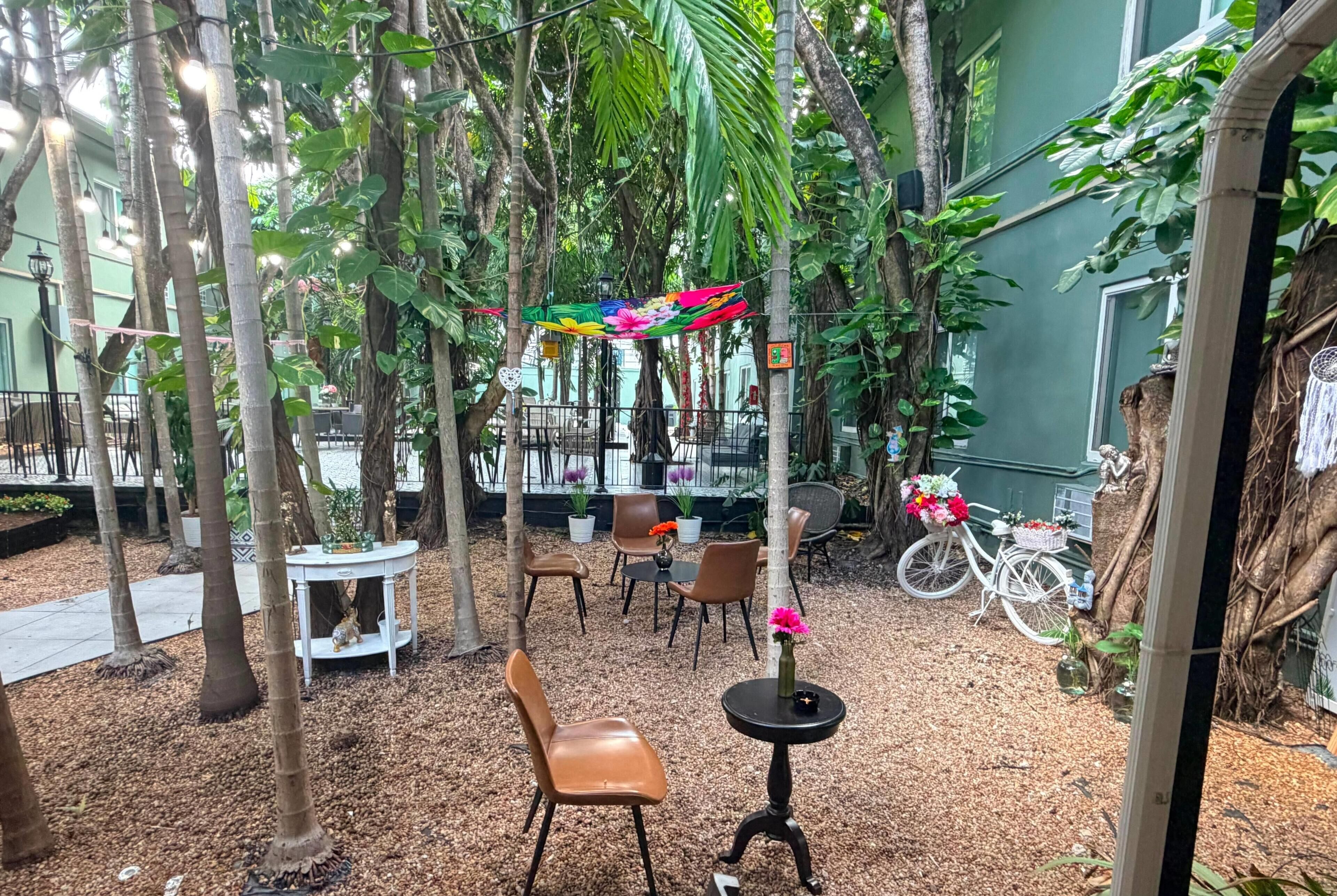 An indoor garden with seating, tables, and decorative plants.
