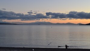 A calm lake with mountains in the background and a clear sky. - Colonial Lodge Motel (Taupo)