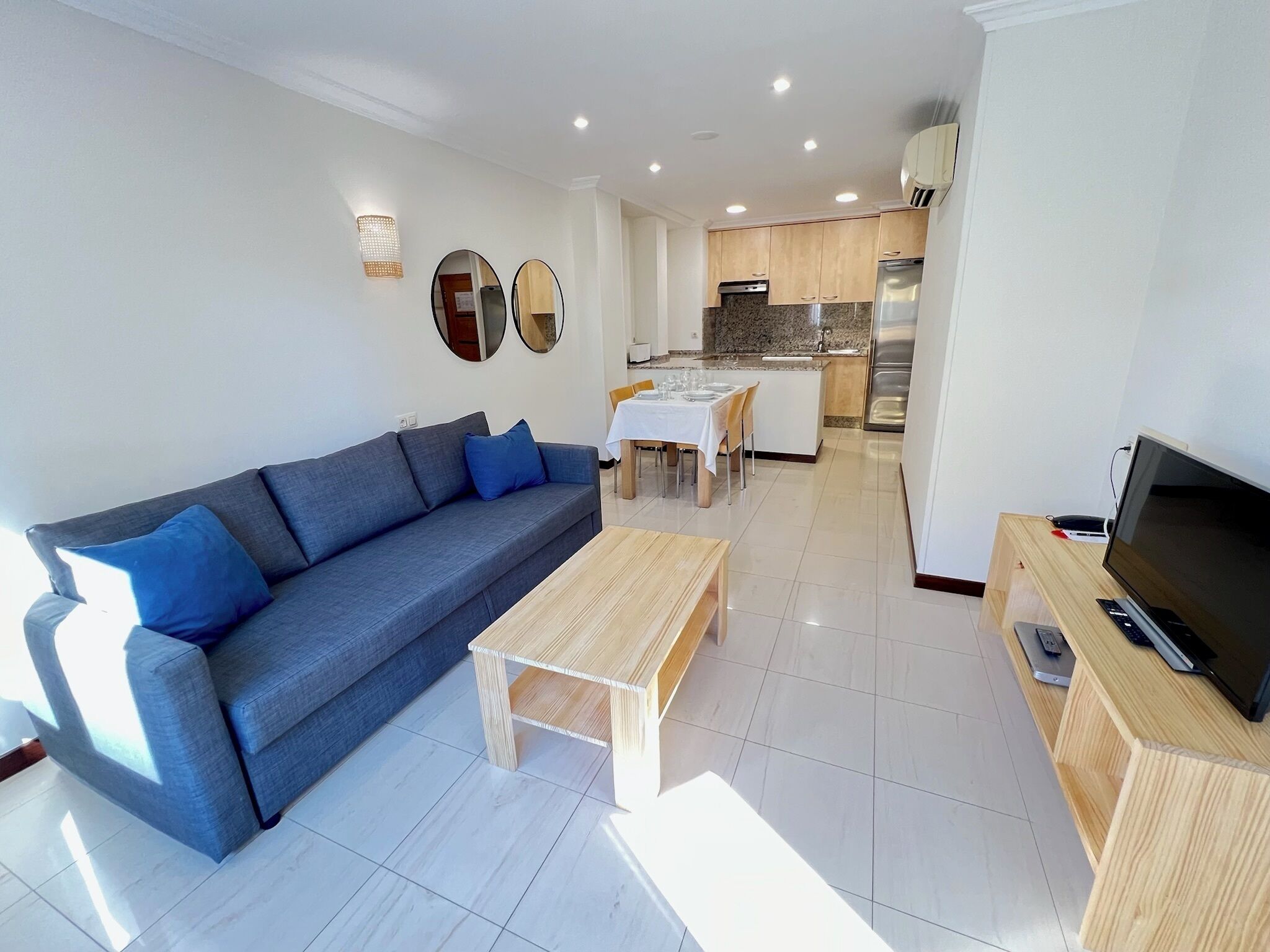 A modern living room with a sofa, coffee table, and TV stand.