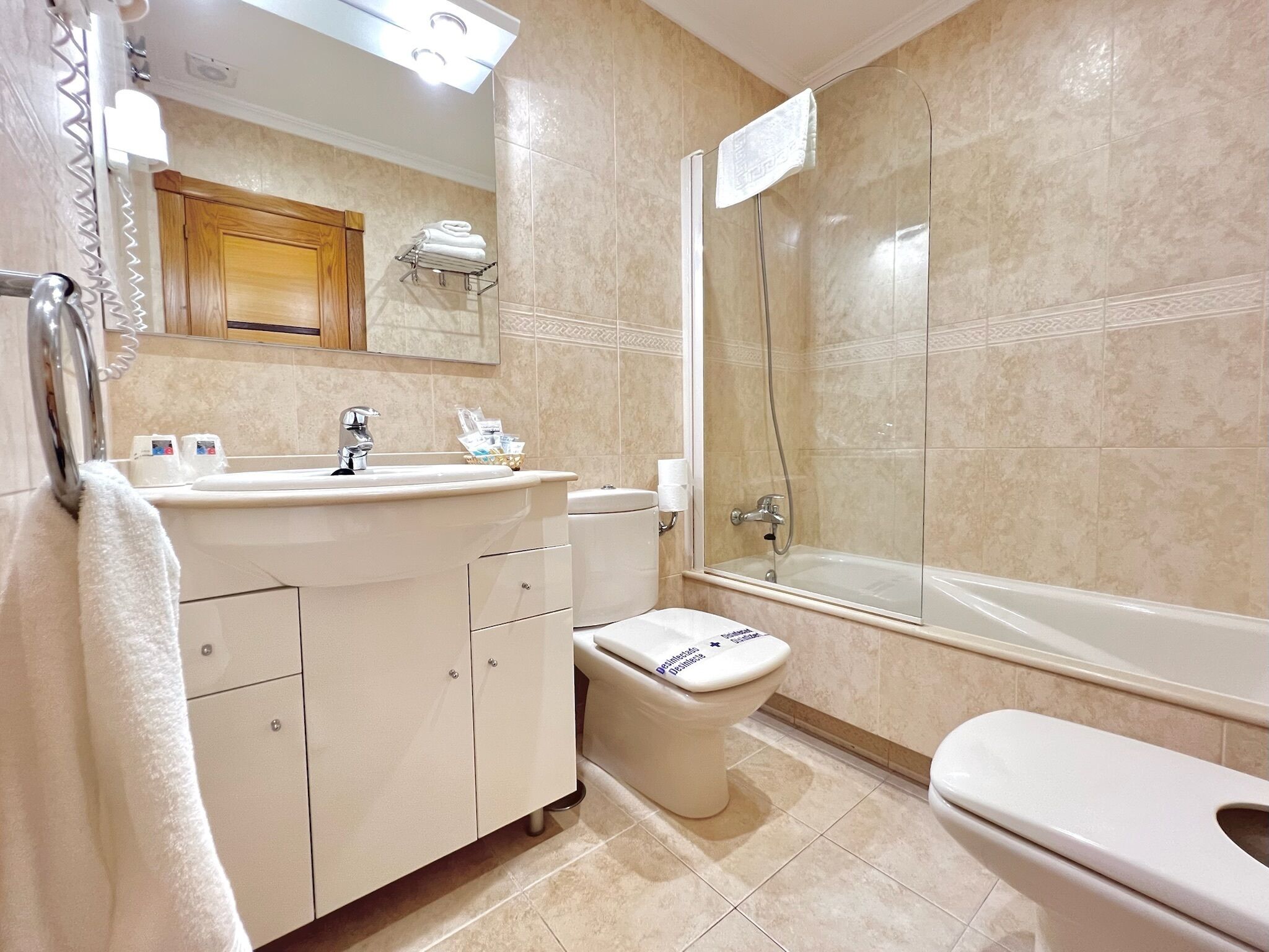 A bathroom with a sink, toilet, and shower.