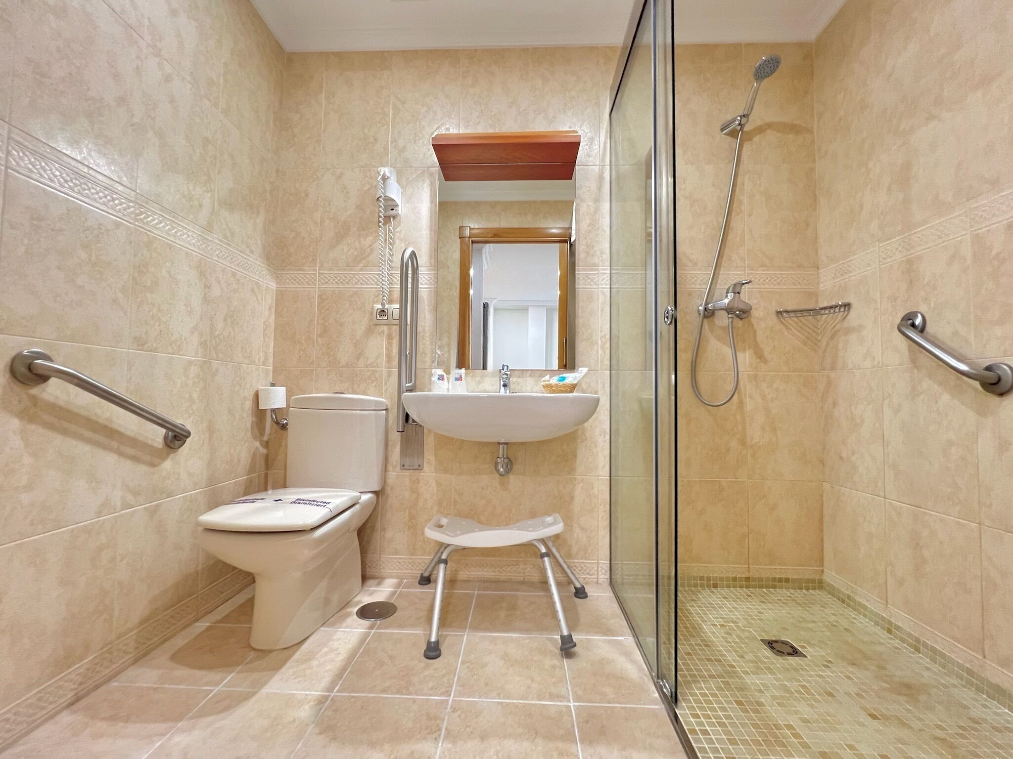 Een moderne badkamer met toilet, wastafel en douche.