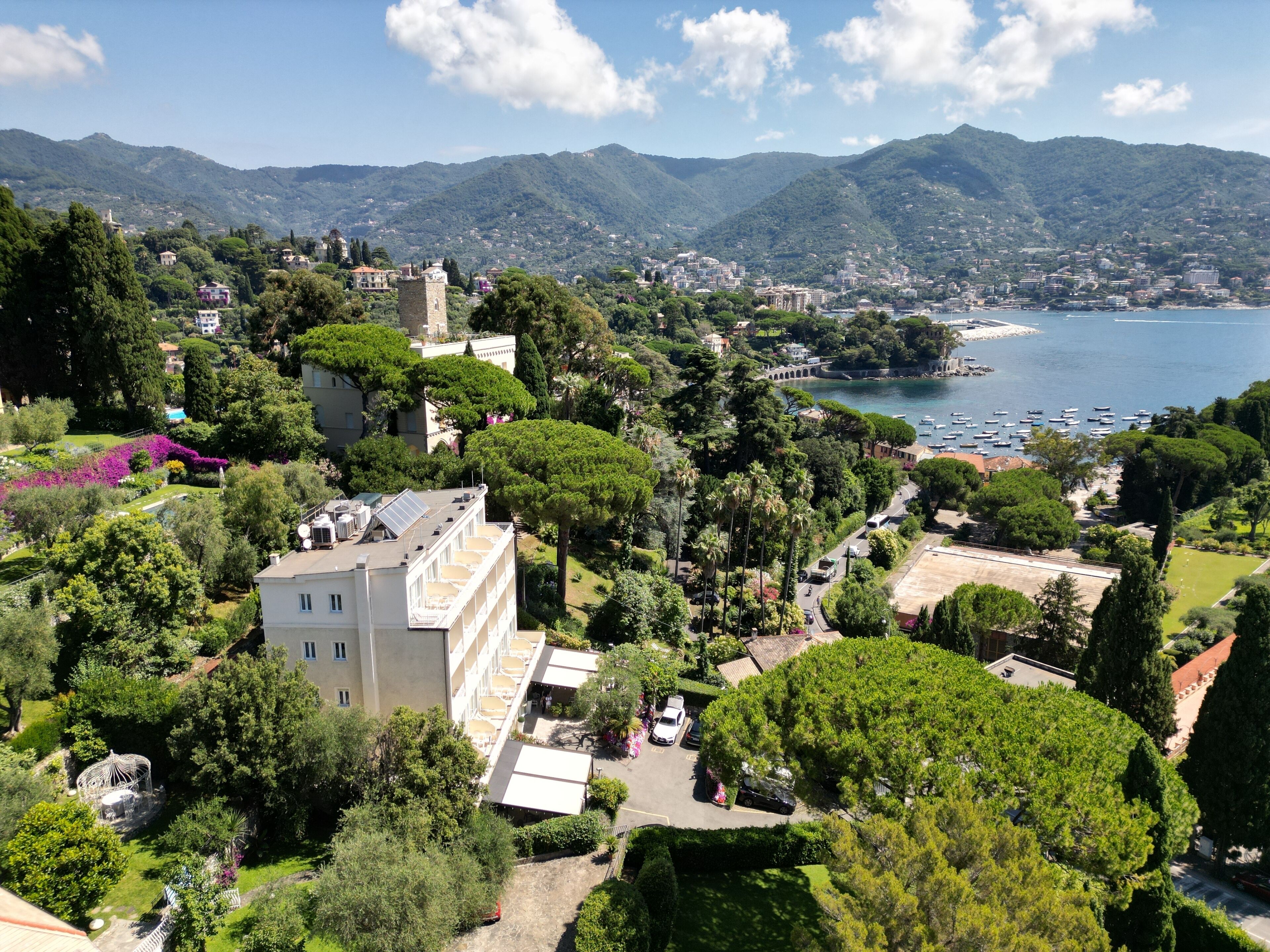 A coastal town with a prominent tower, lush greenery, and a marina.