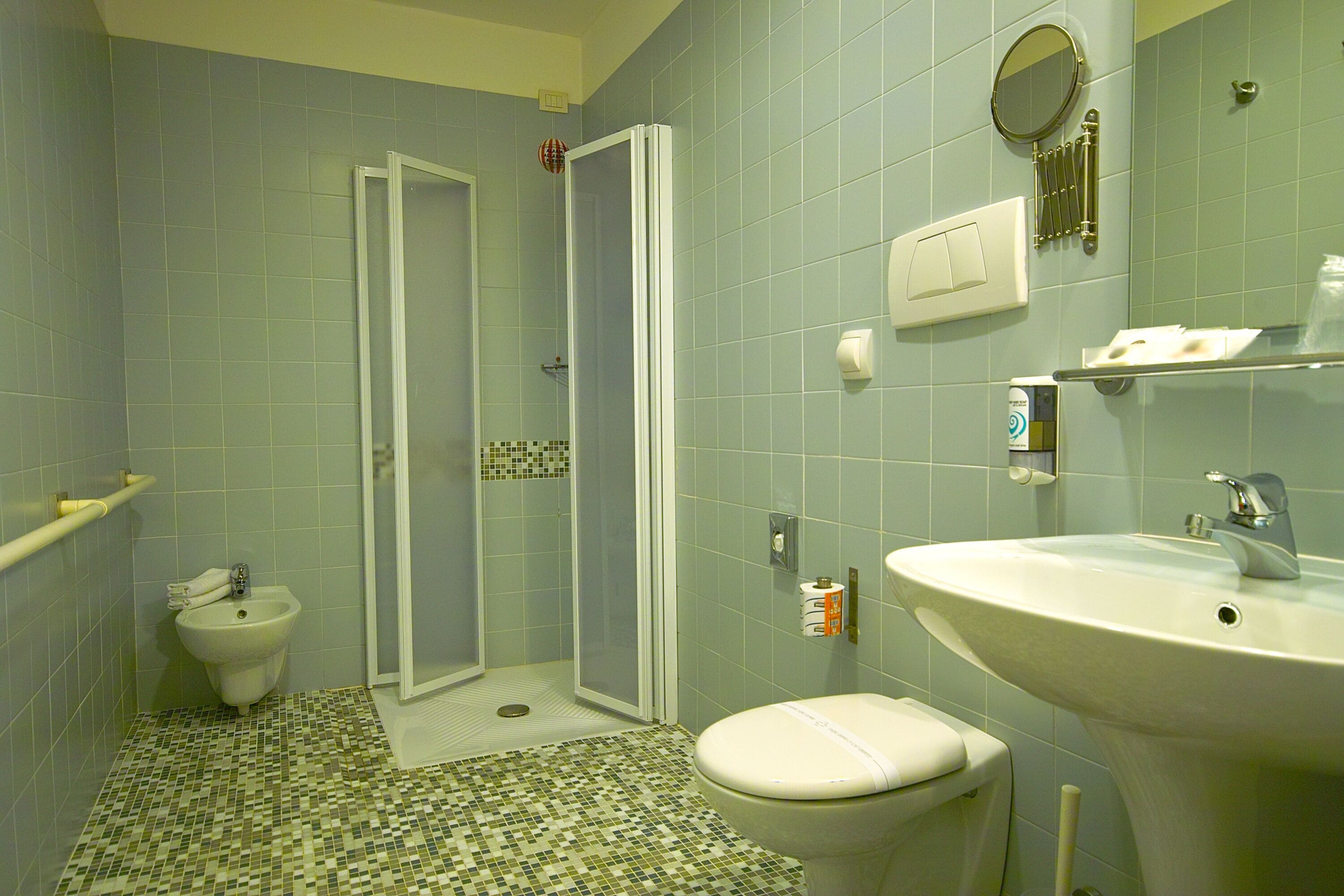 Un baño con bidé, inodoro, lavamanos y cabina de ducha.