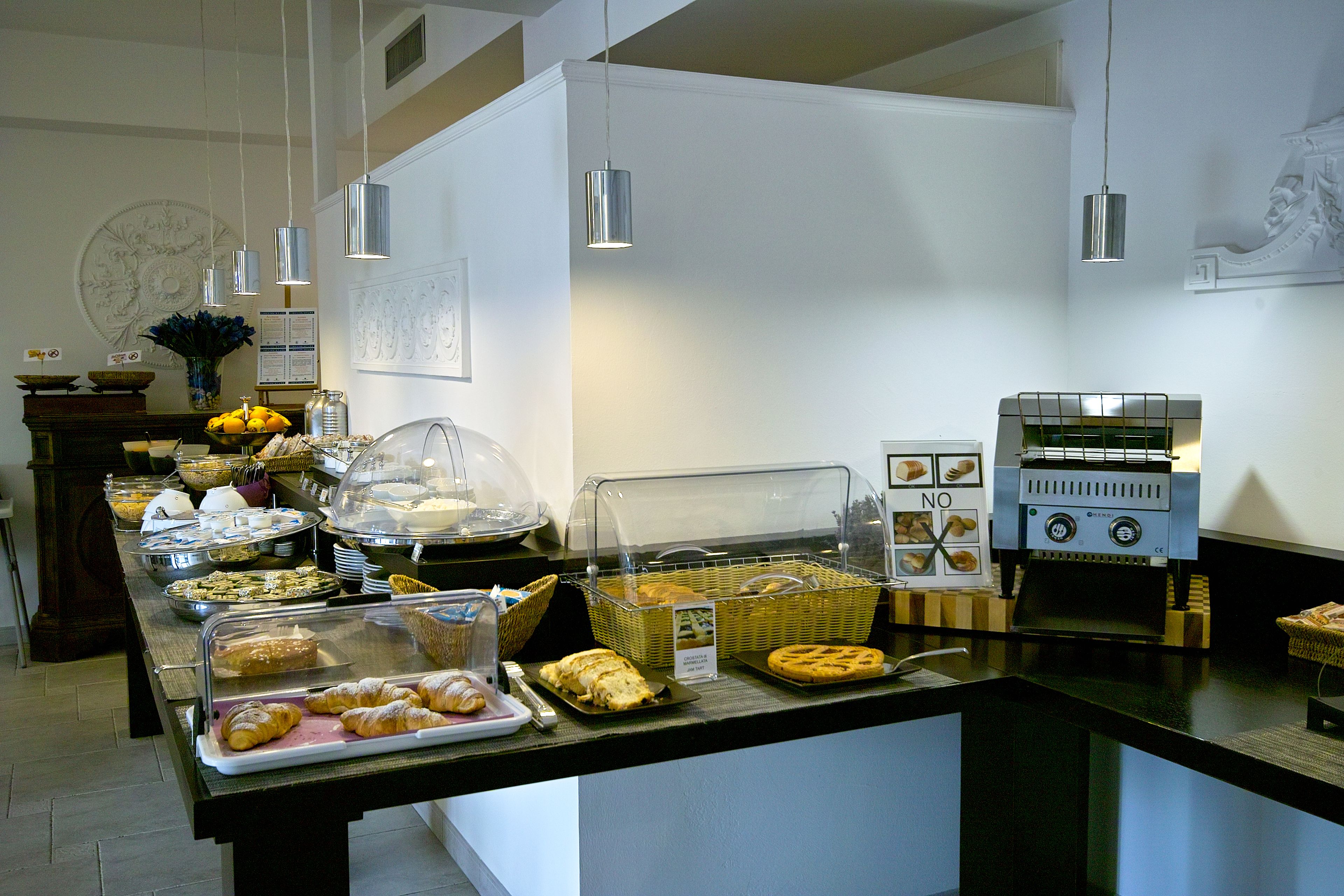 A buffet area with various food items, a coffee machine, and a decorative wall piece.