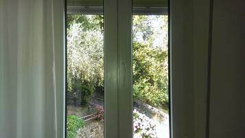 Una finestra vista giardino, ricco di piante e fiori.