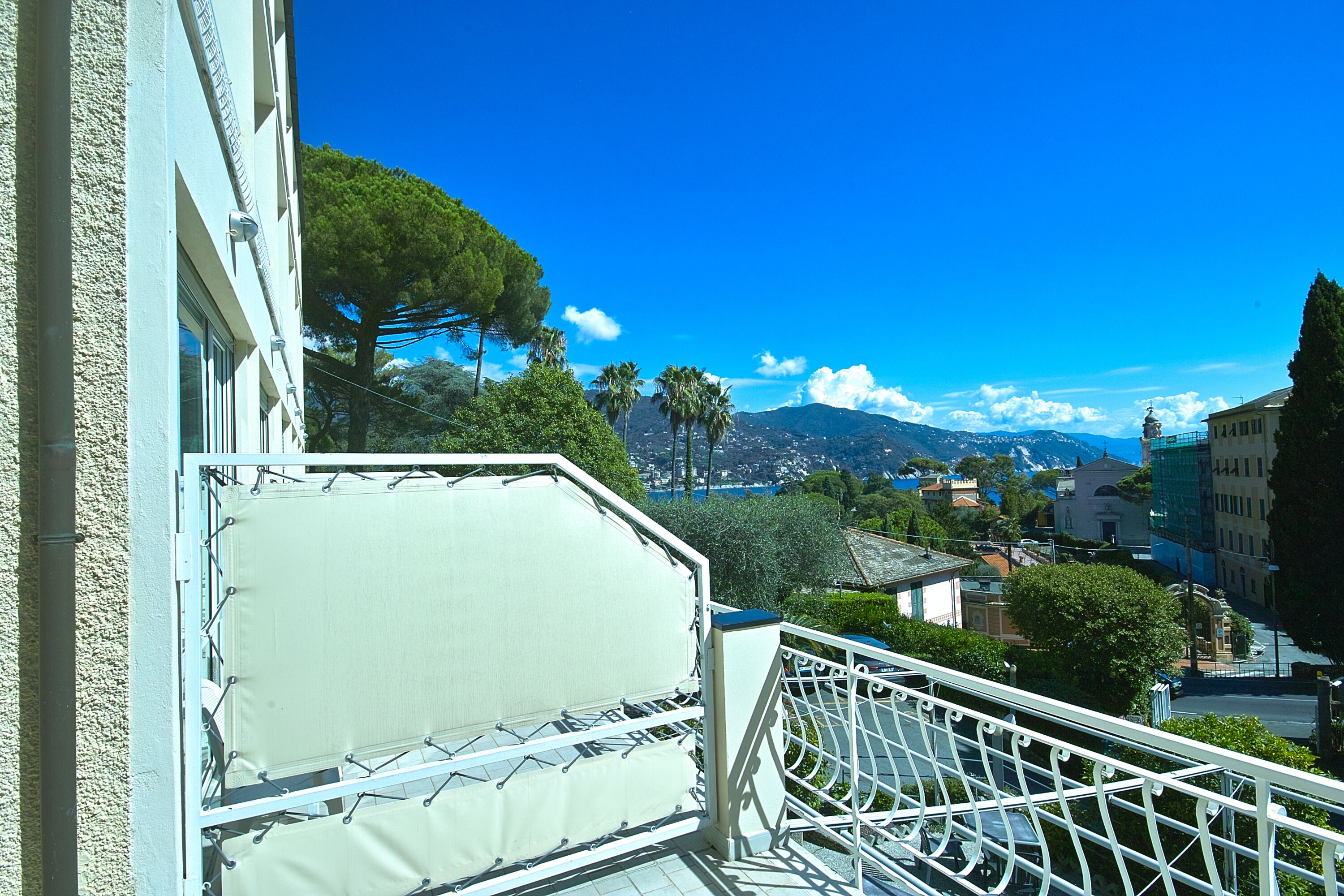 Ein Balkon mit Blick auf eine Stadtlandschaft, einschließlich Gebäude und Berge.