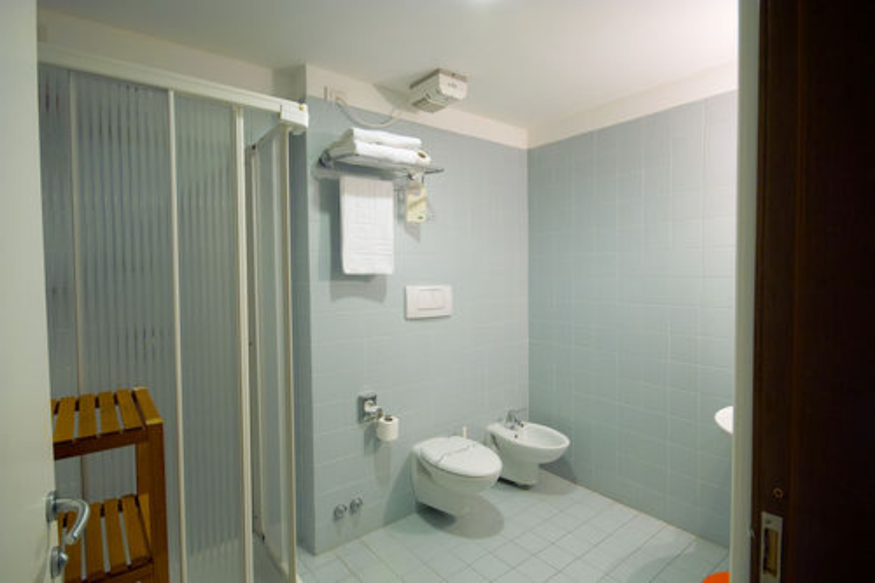 Une salle de bain comprenant des toilettes, un bidet et un espace douche.