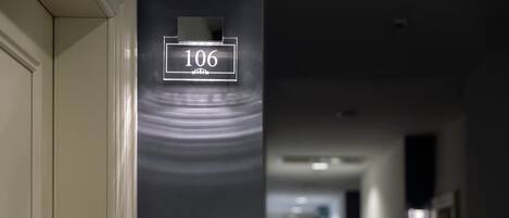 A hallway with a sign indicating room number 106.