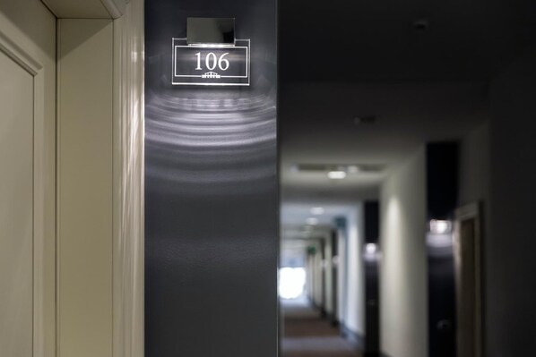 Un couloir avec une pancarte indiquant le numéro de la pièce : 106.
