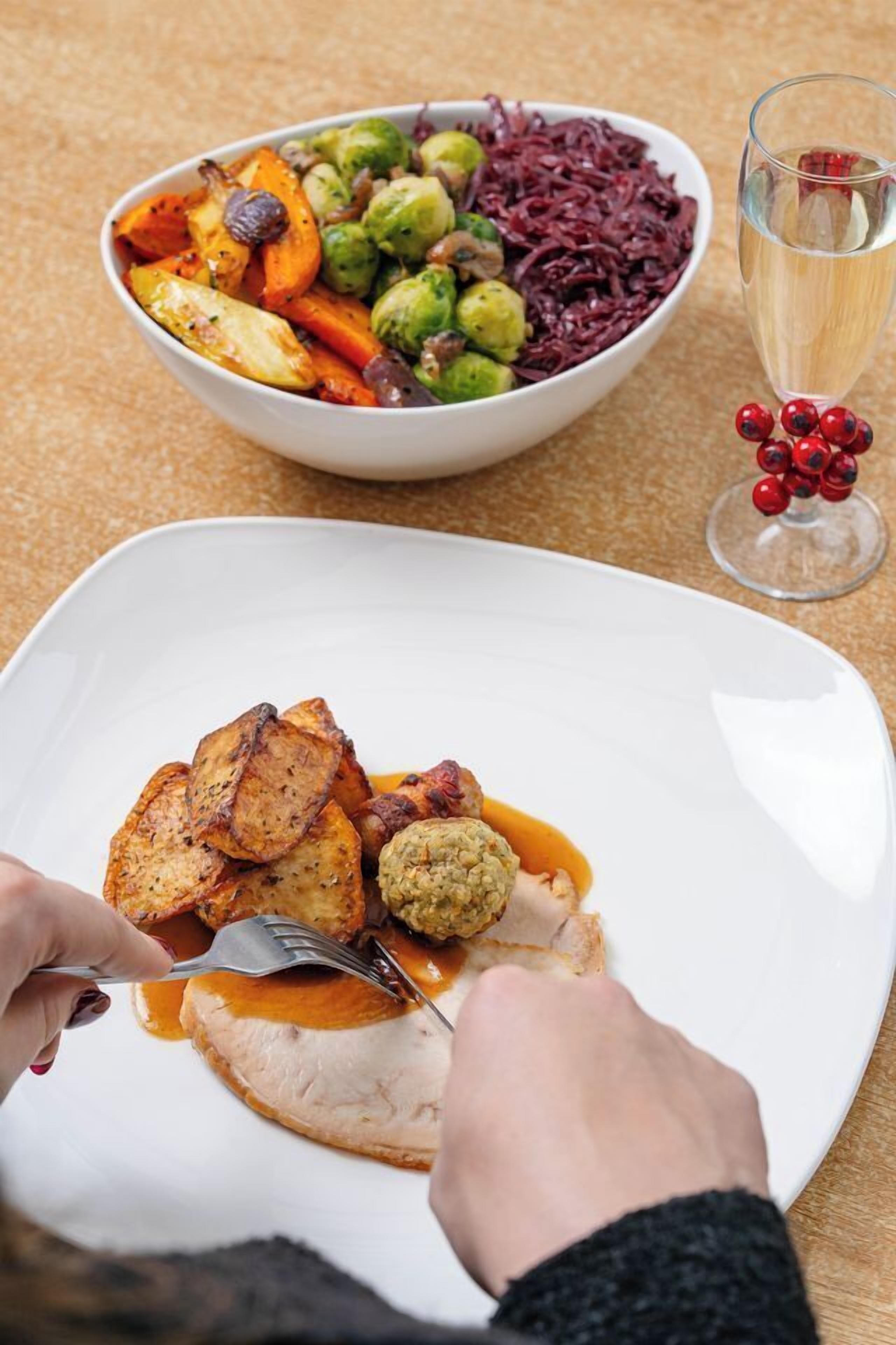 A dining table with a plate of food, a bowl of mixed vegetables, and a glass of water.