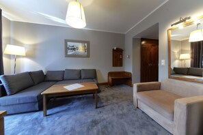 A living room with a gray sectional sofa, a beige sofa, a wooden coffee table, and a framed picture on the wall. - Skalny (Zakopane)