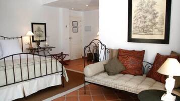 A bedroom with a bed, a bedside table, a lamp, and a framed picture on the wall.
