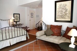 A bedroom with a bed, a bedside table, a lamp, and a framed picture on the wall.