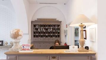 A reception desk with a globe, a lamp, and a wall-mounted display case with letters.