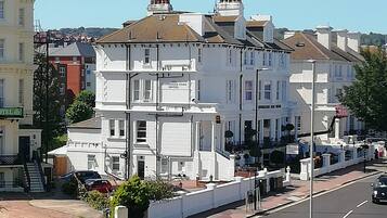 Uma fileira de edifícios brancos com uma placa indicando 'Plymstock Park Hotel'.