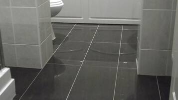 Een badkamer met toilet, wastafel en bad.