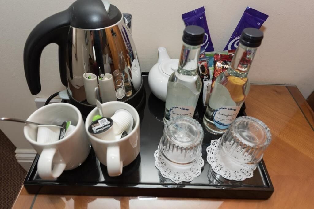Una safata amb una cafetera, dues tasses, dues ampolles d'aigua i una teiera.