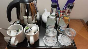 Una safata amb una cafetera, dues tasses, dues ampolles d'aigua i una teiera.