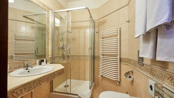 Une salle de bain avec une douche à parois de verre, un lavabo et des toilettes.