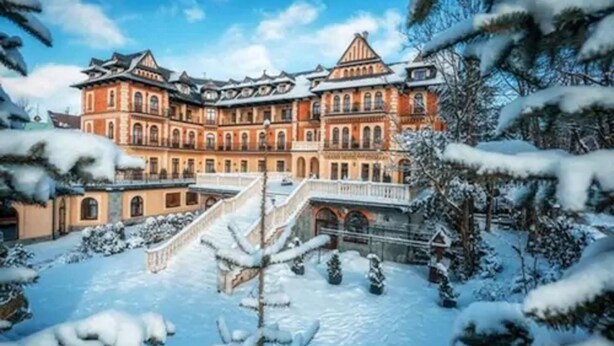 Un edificio grande e histórico con varios niveles y una escalera central.