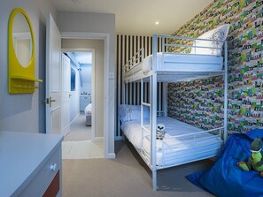 A bunk bed room with a striped wall, a mirror, and a colorful wall pattern. - Wild Garlic Rooms (Stroud)