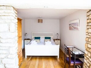 A bedroom with a bed, bedside tables, a desk, and a chair. - Wild Garlic Rooms (Stroud)