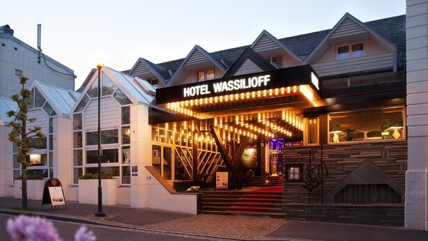 A hotel with a modern facade, a prominent entrance with steps, and a sign reading "HOTEL WASSILIOFF". - Hotel Wassilioff - Unike Hoteller (Larvik)