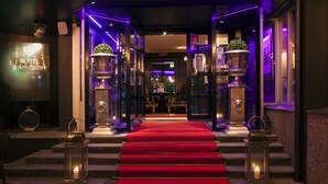 A hotel entrance with a red carpet leading to a reception area. - Hotel Wassilioff - Unike Hoteller (Larvik)