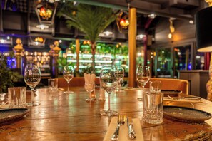 A restaurant table set with wine glasses, a water glass, and cutlery. - Hotel Wassilioff - Unike Hoteller (Larvik)