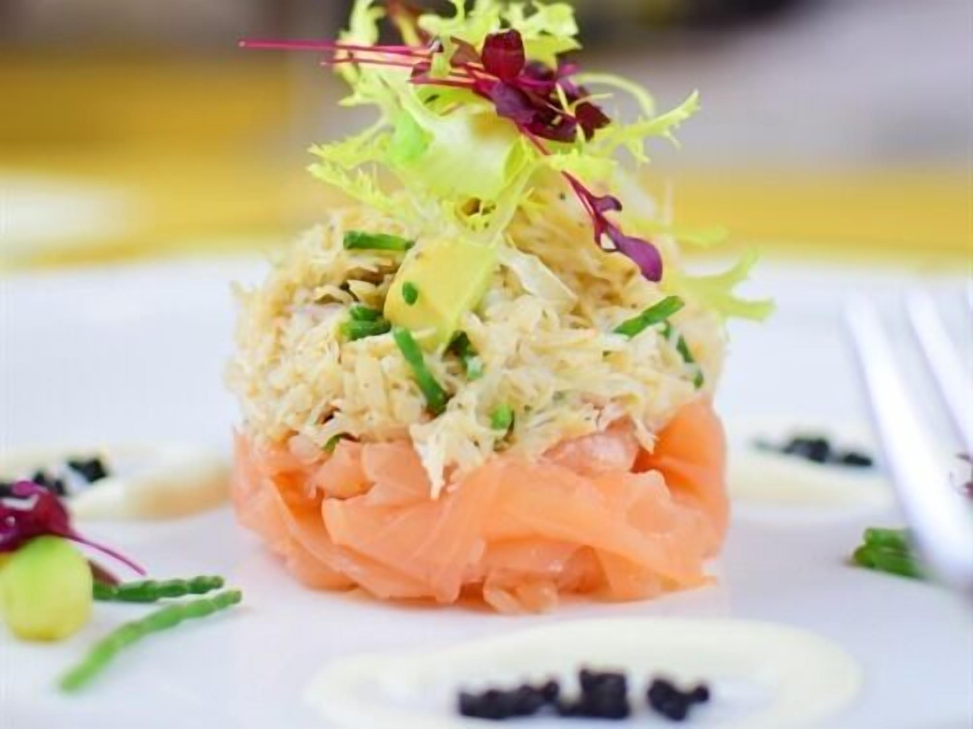 A dish with shredded ingredients and salmon on a white plate.