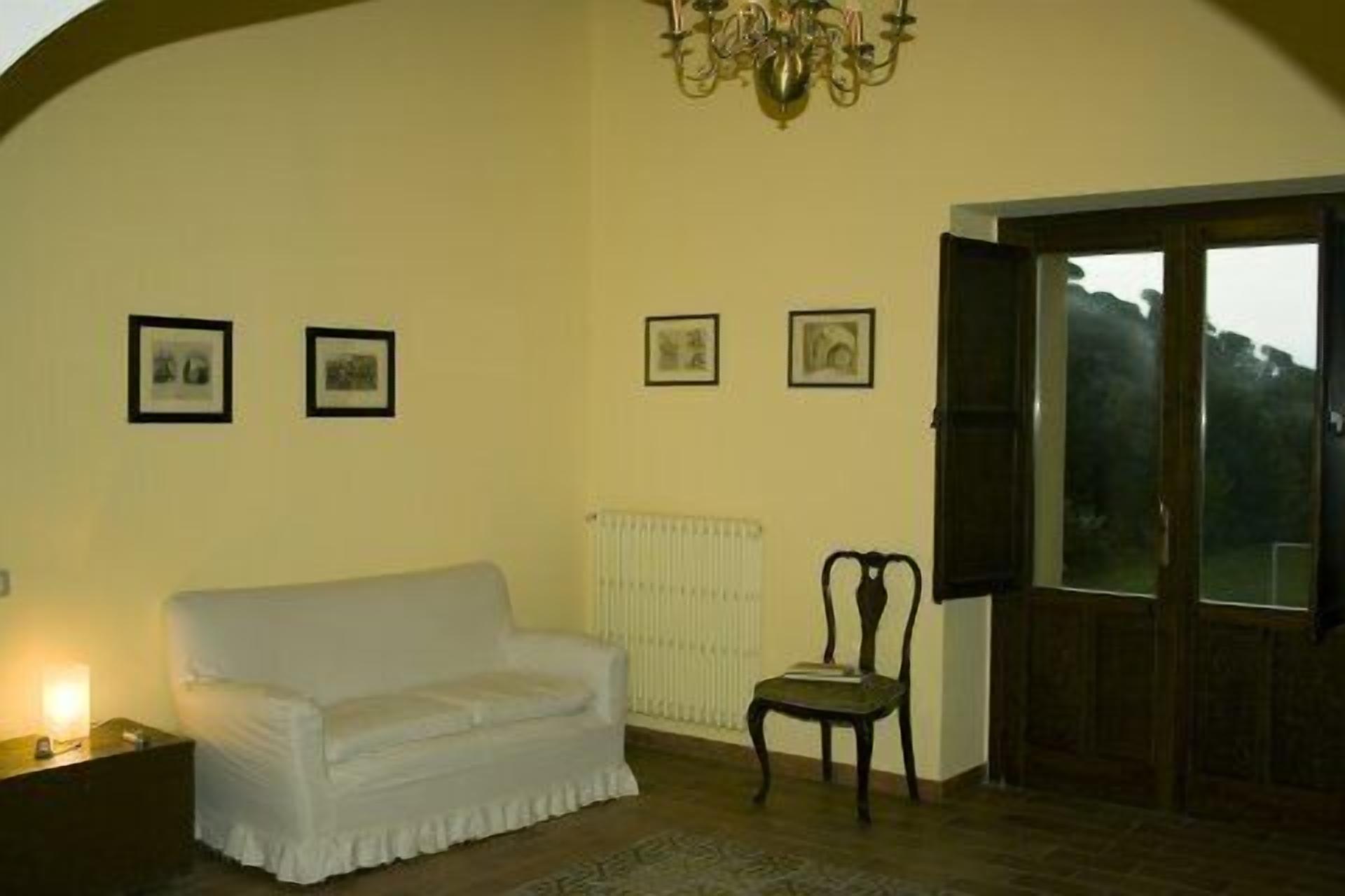 Ein Zimmer mit weißem Sofa, einem Sessel, einer Heizung und einer Deckenleuchte.
