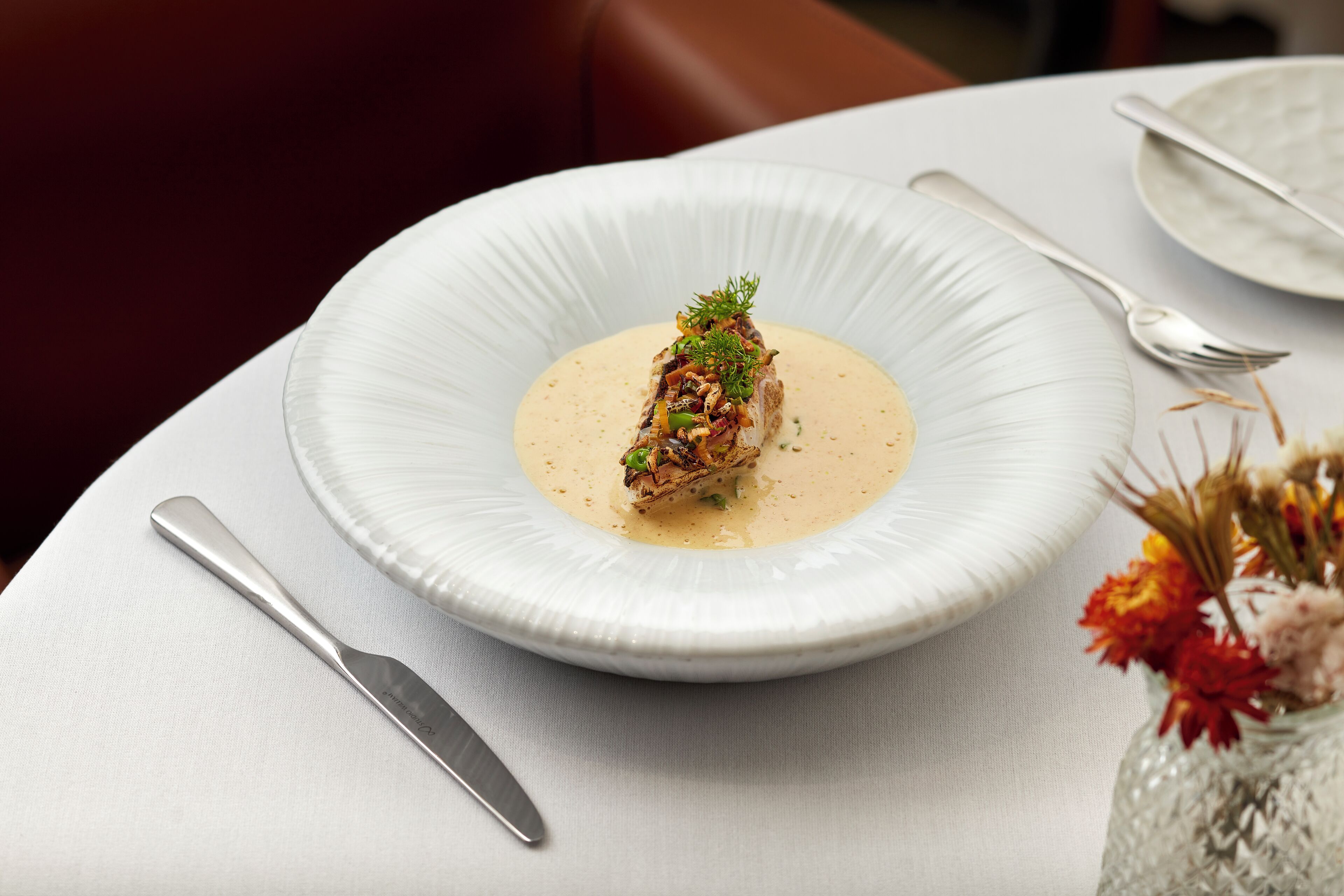 A white plate with a piece of food and a spoon on a table.