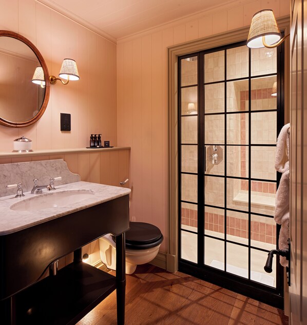 A bathroom with a marble sink, a toilet, a large window with a view, and a towel hanging on the door. - Penmaenuchaf Hotel (Dolgellau)