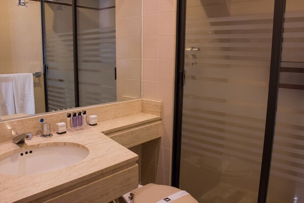 A bathroom with a sink, mirror, and toiletries.