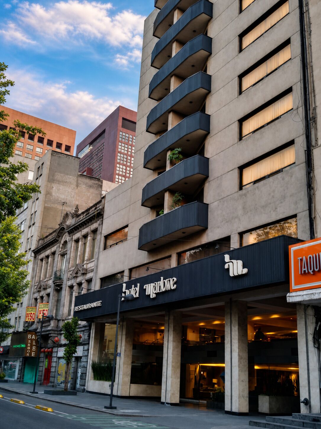 A hotel with a modern facade, multiple balconies, and a restaurant sign.
