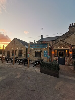 A stone building with a sign reading "The Red Well Inn" and outdoor seating. - The Redwell Inn (Barnard Castle)